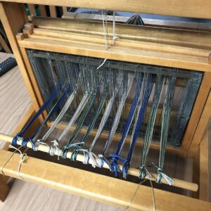 Tying yarns onto the back of the loom